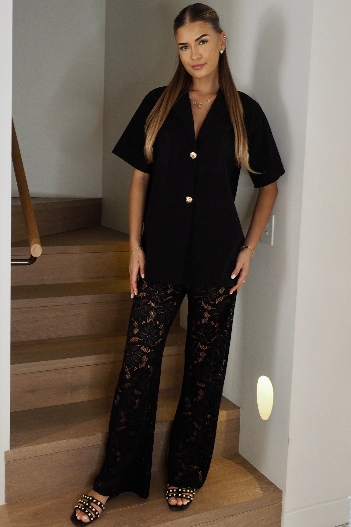 Women's black two piece set with collared shirt and sheer lace trousers