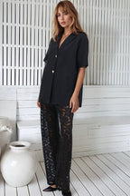 Women's black two piece set with collared shirt and sheer lace trousers