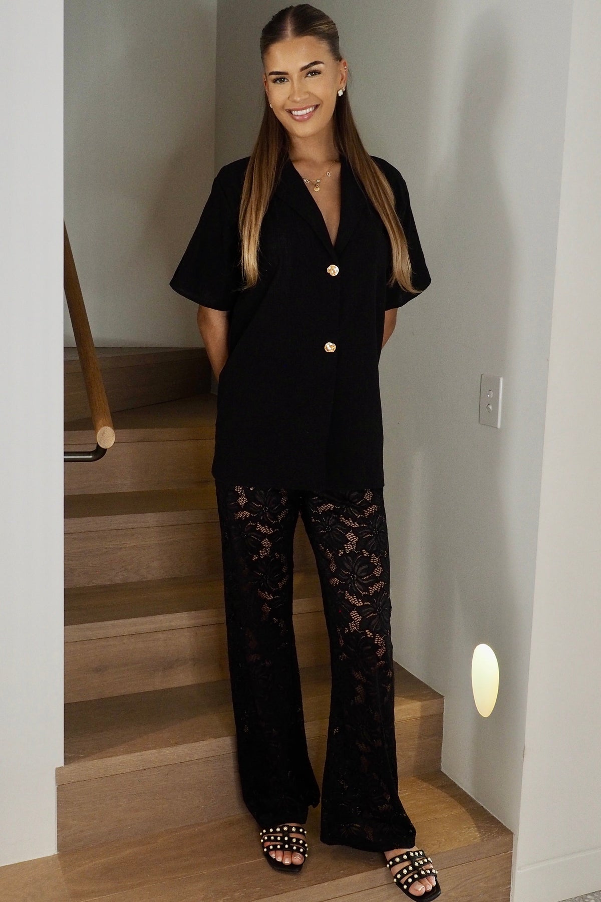 Women's black two piece set with collared shirt and sheer lace trousers